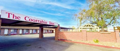 The Coorbin Inn with a covered parking area and a brick wall.