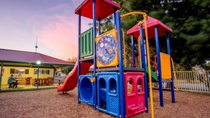 A playground with a slide, climbing structures, and a covered seating area. - Big4 Shepparton Park Lane (Kialla)