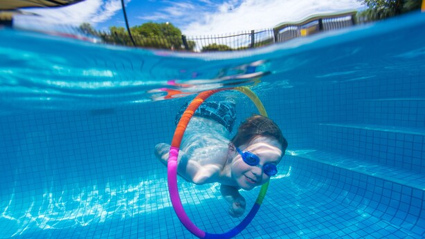 A person swimming in a pool with a colorful ring. - Big4 Shepparton Park Lane (Kialla)