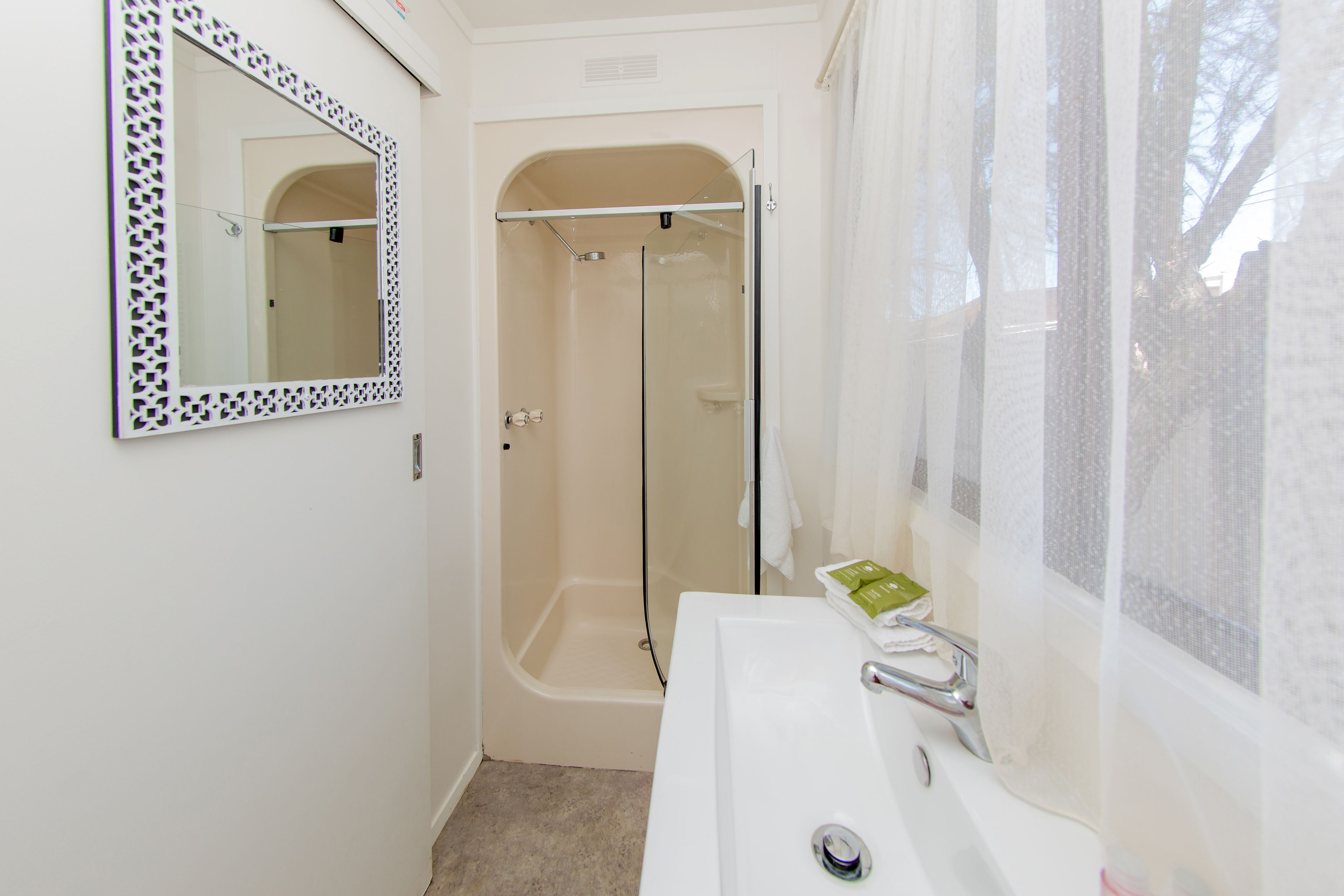 Un baño con ducha, lavabo y espejo.