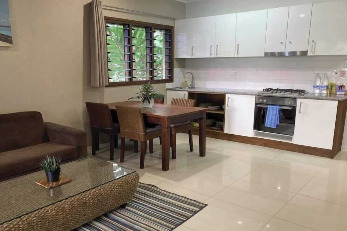 A compact living space with a dining area, kitchenette, and a sofa.