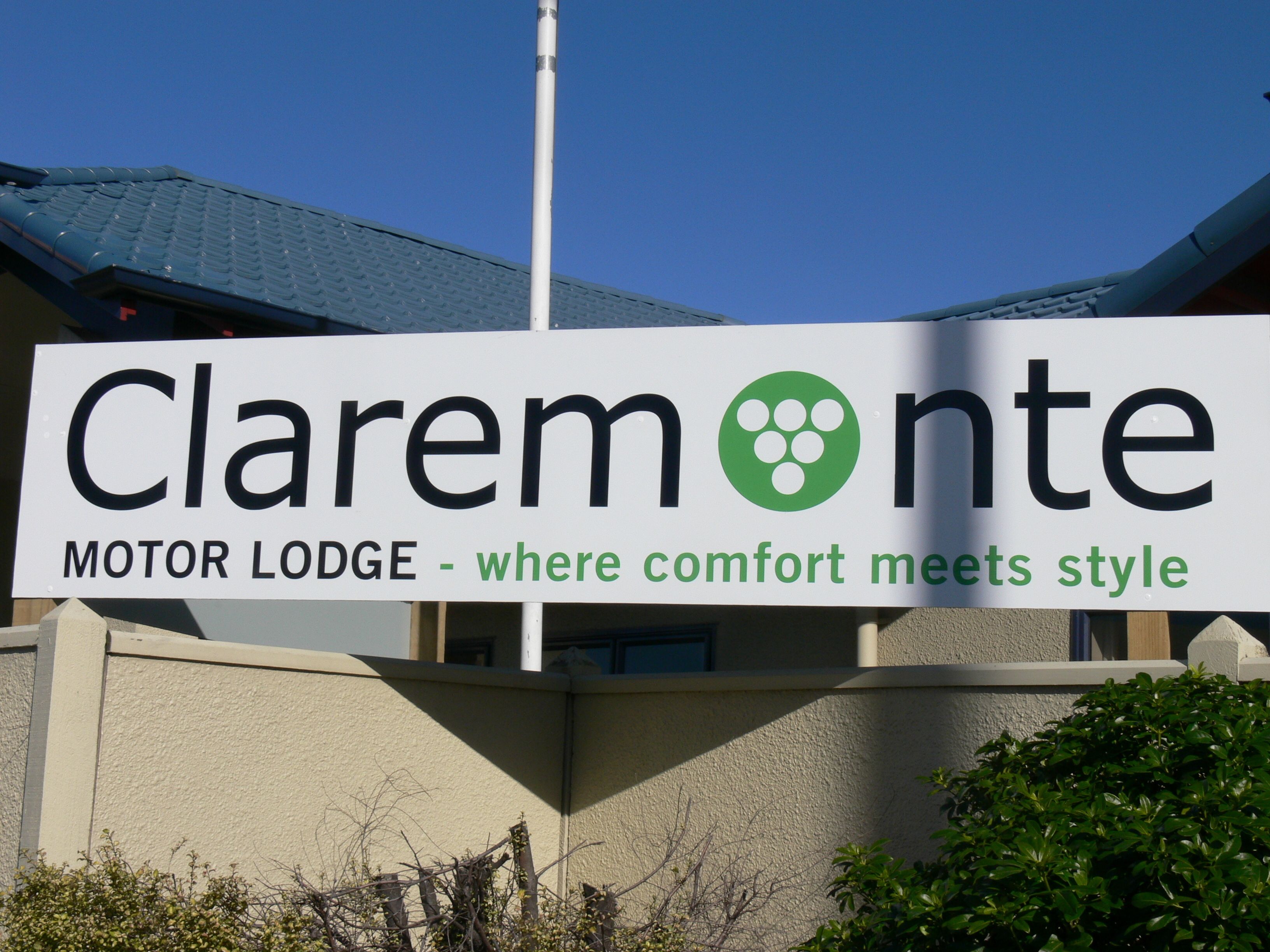 Une enseigne indiquant « Claremont Motor Lodge, l’endroit où le confort rencontre le style ».