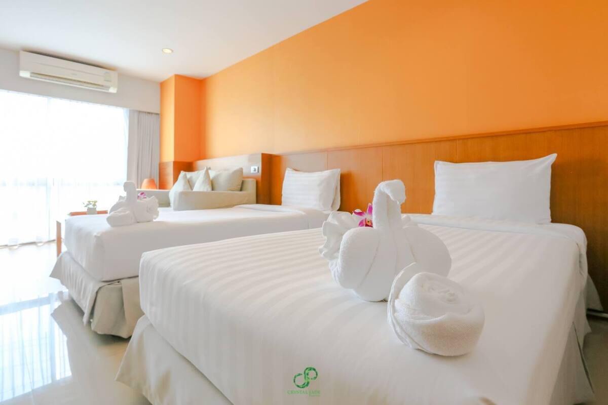 Habitación de hotel con dos camas, cada una decorada con toallas con forma de cisne.