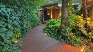 A wooden pathway leading to a building surrounded by lush greenery. - Misty View Cottages Montville (Montville)