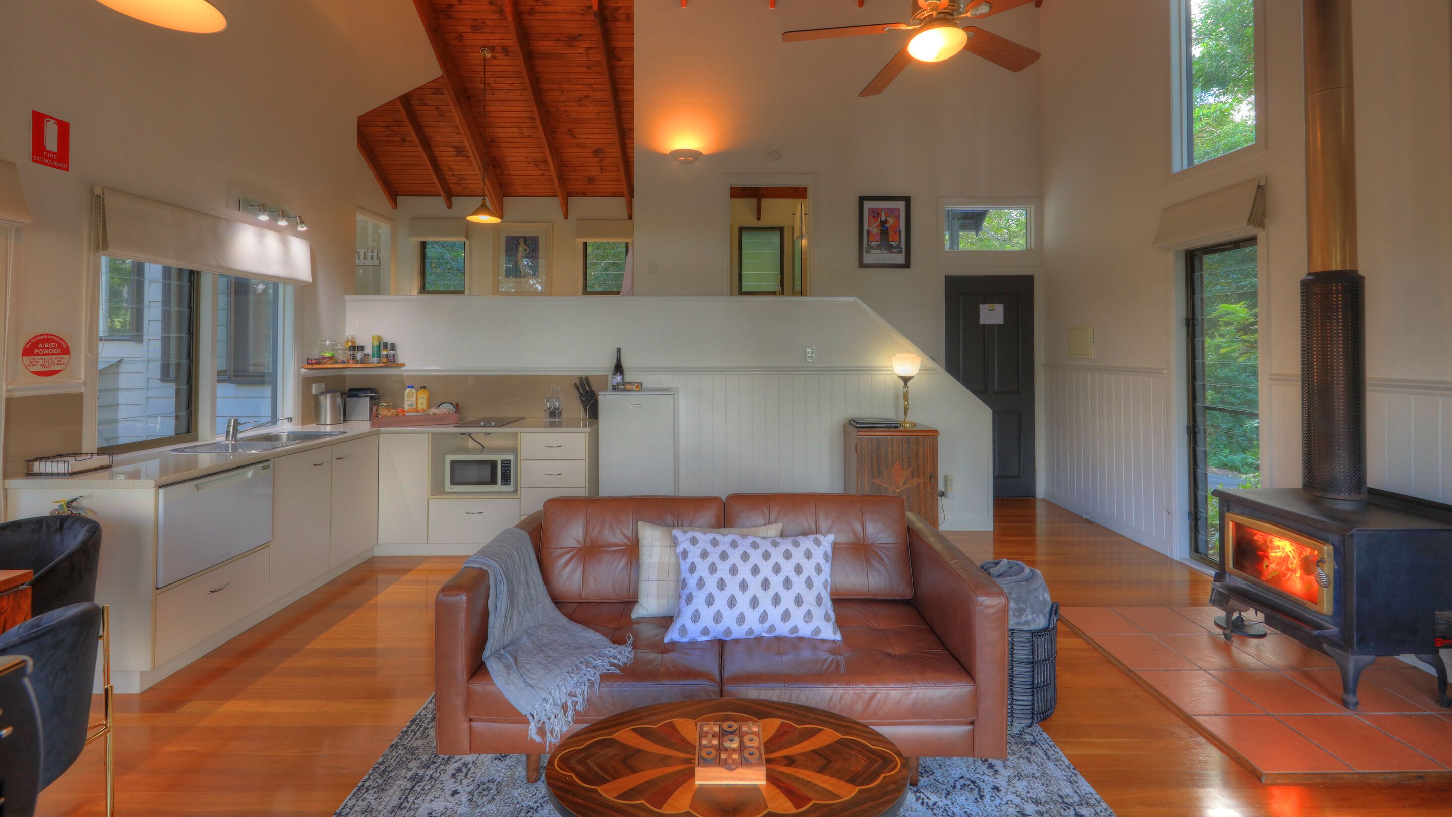 A cozy living room with a leather sofa, a coffee table, and a fireplace.