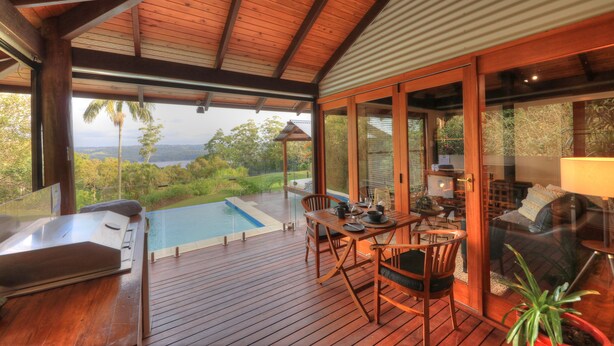 A wooden deck with a pool, dining area, and a view of the landscape. - Misty View Cottages Montville (Montville)
