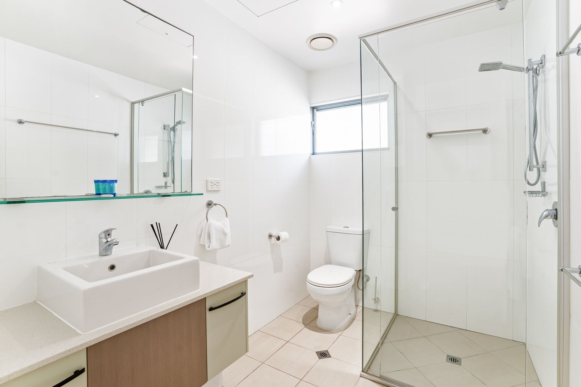Une salle de bain moderne avec une douche à parois de verre, un lavabo blanc et des toilettes.