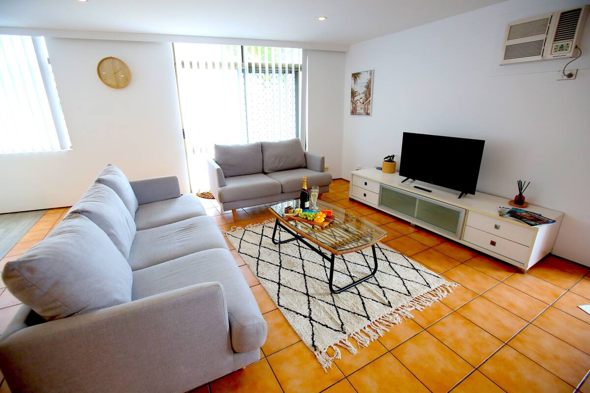 A living room with a sofa, a coffee table, a TV, and a cabinet.