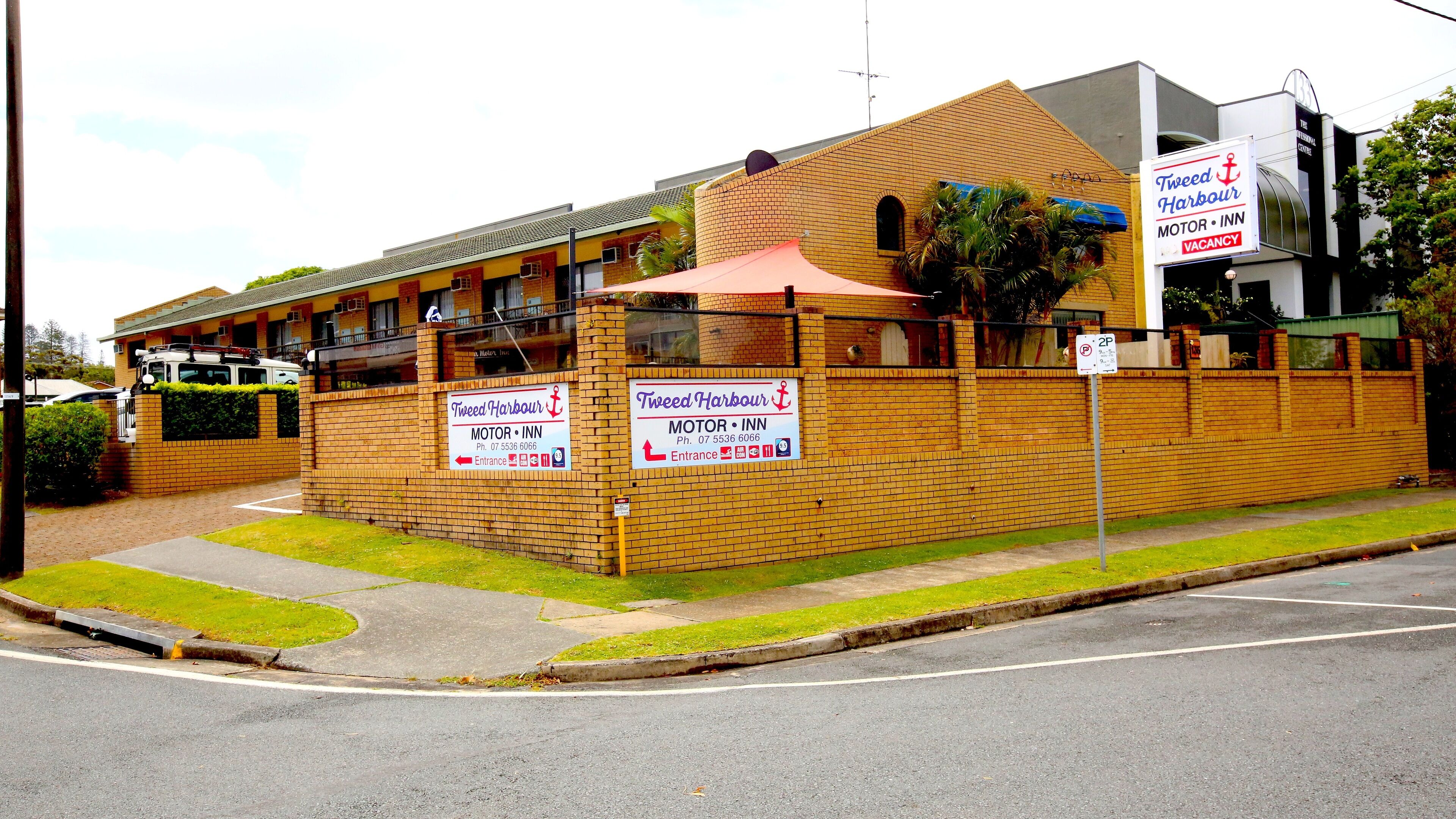 Edificio de ladrillo con letreros que anuncian un motel llamado Tweed Harbour.