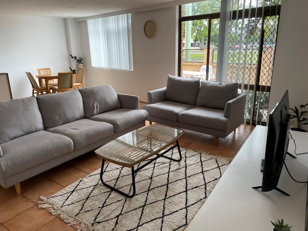Een woonkamer met twee banken, een salontafel en een televisie.