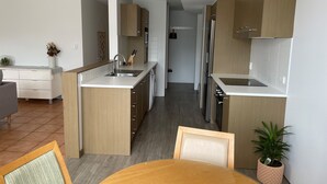 A modern kitchen with wooden cabinets, a built-in sink, and stainless steel appliances. - Tweed Harbour Motor Inn (Tweed Heads)