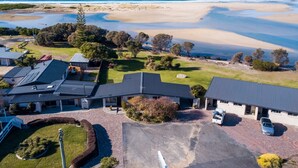 A coastal property with a paved driveway, a garage, and a parking area.