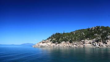 A coastal landscape with a rocky shoreline and calm sea.