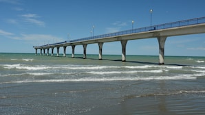 A pier extending into the ocean with a clear sky above. - Beachlife Apartments (Christchurch)