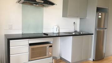 A modern kitchen with a built-in oven, stainless steel appliances, and a black countertop.