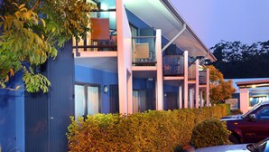 A modern hotel with multiple balconies, a covered outdoor area, and a parking lot. - Manly Marina Cove Motel Brisbane (Manly)