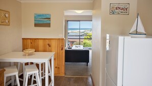Una cocina con vista a la playa, una decoración de velero y un letrero que dice 'ENJOY the BEACH'.