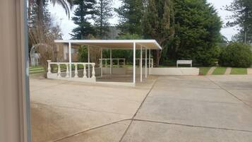 Relax under the shade of a pergola, surrounded by lush greenery and a serene atmosphere.