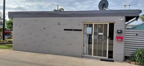 A small, single-story building with a brick exterior, a satellite dish, and a door with a security keypad. - Kaputar Motel Narrabri (Narrabri)