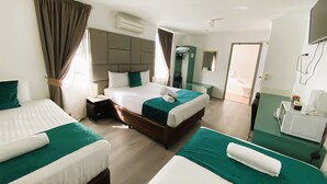 Habitación de hotel con dos camas, un baño y televisión.