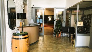 Una zona de recepción con mostrador, espejo, un barril de madera y un árbol de Navidad.