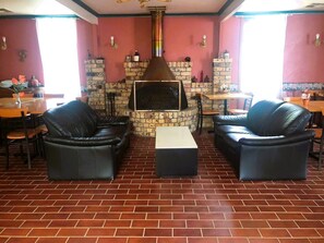 Relax by the warm fireplace in this inviting lounge area, featuring comfortable sofas and a casual dining space.