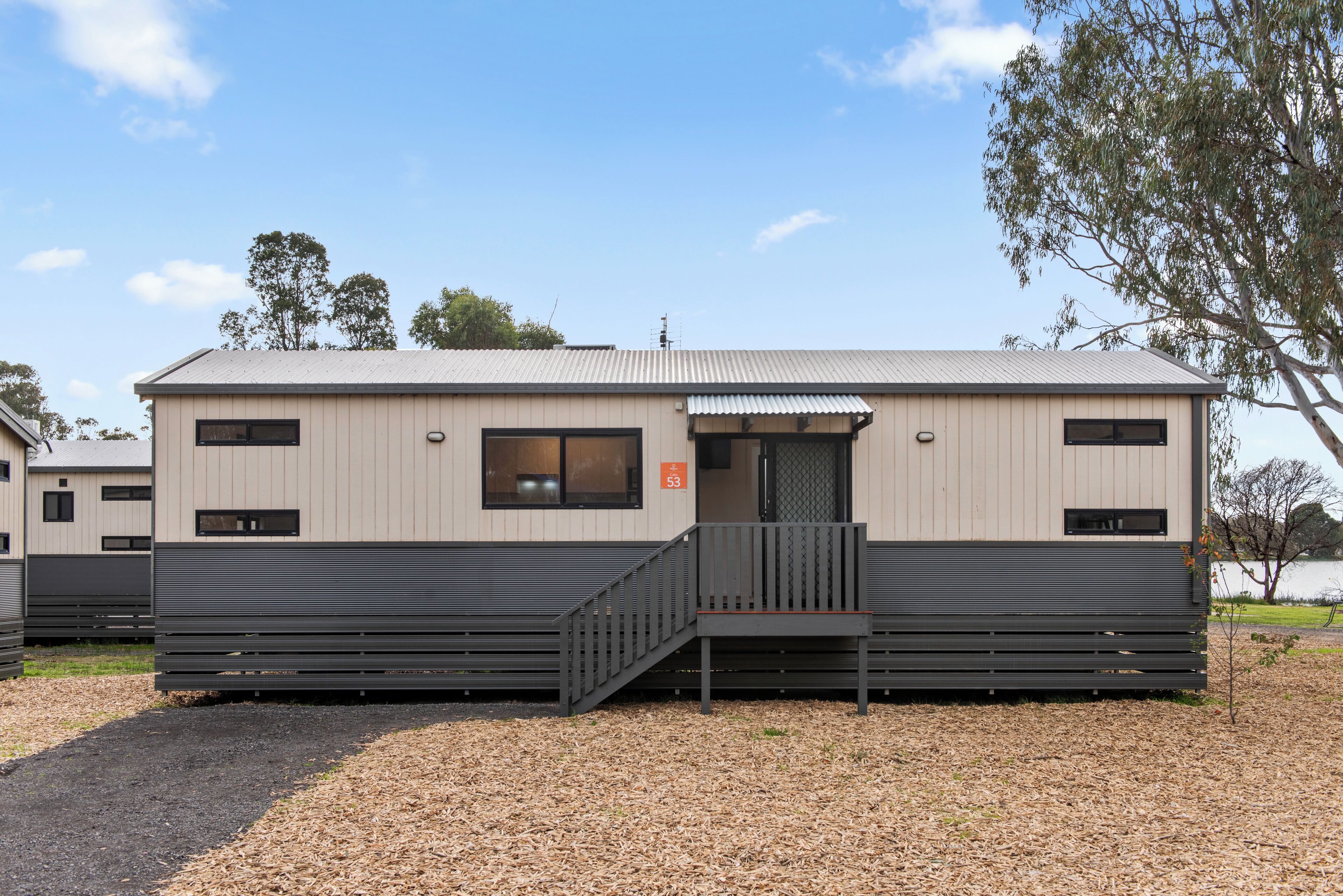 A building with a flat roof, a small entrance, and a staircase leading to the door.