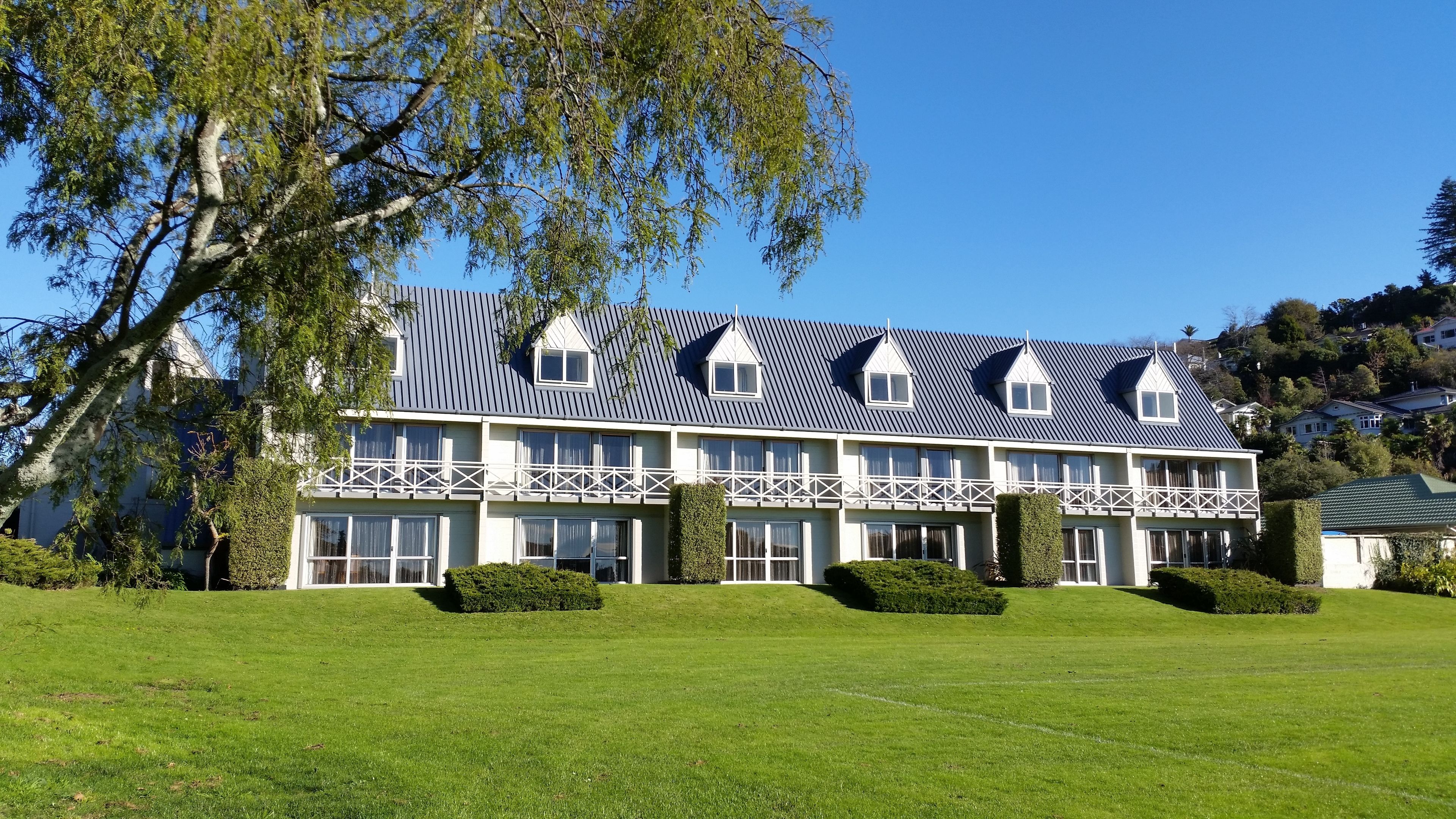 A large, two-story building with a symmetrical facade, multiple windows, and a prominent roofline.