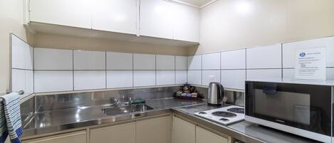 A modern kitchen with white cabinets, stainless steel appliances, and a microwave.