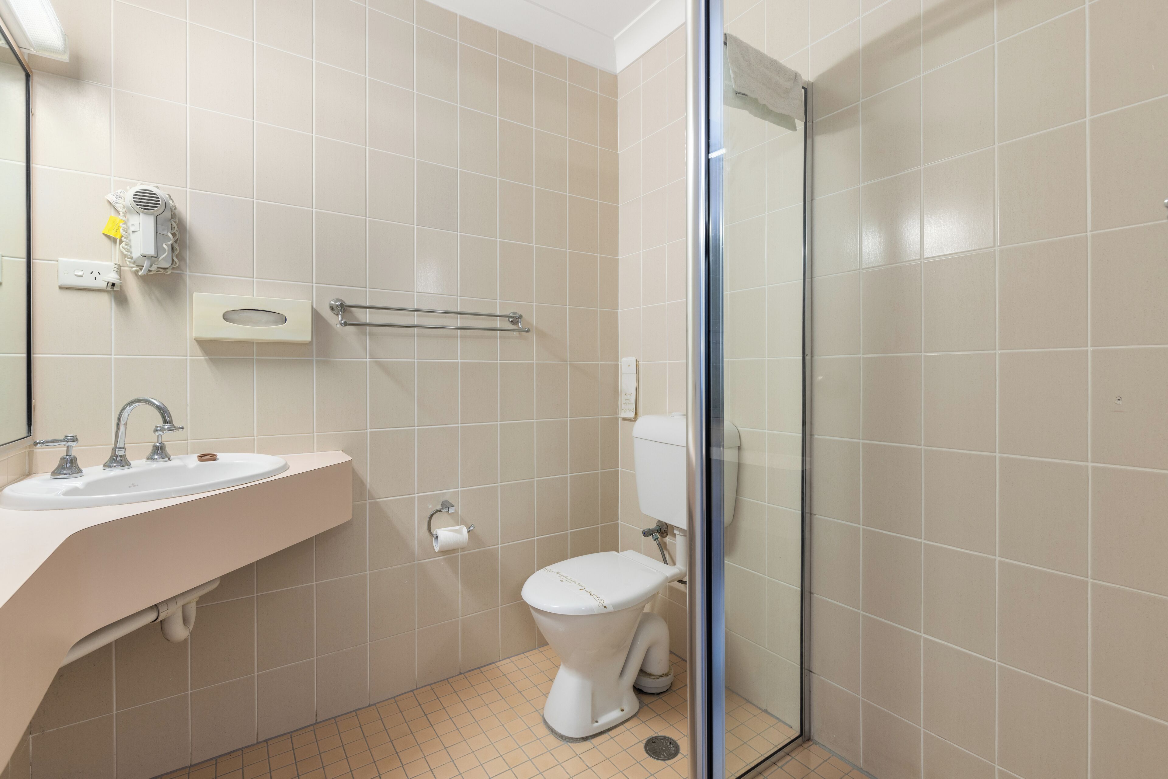 A bathroom with a sink, toilet, and a glass shower enclosure.