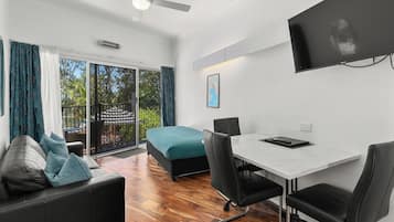 A modern room with a bed, a desk, and a TV.