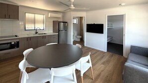 Una cocina moderna con armarios blancos, encimera oscura y horno empotrado.