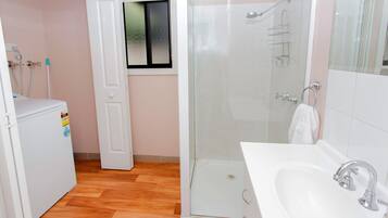 Un baño con ducha, lavabo e inodoro.
