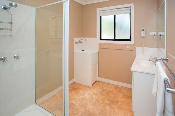 A bathroom with a glass shower enclosure, a sink, and a mirror. - BIG4 Traralgon Park Lane Holiday Park (Traralgon)