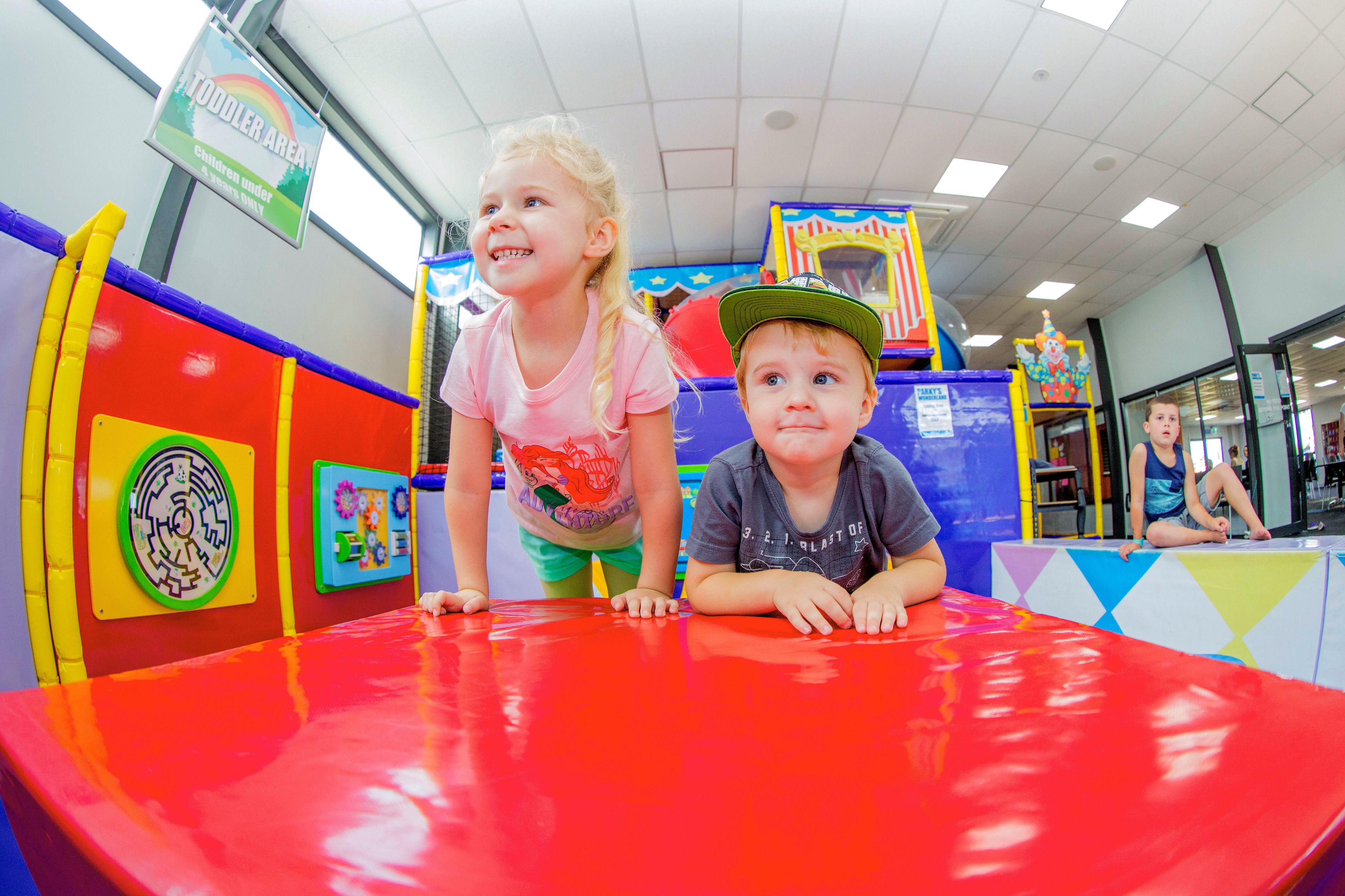 Ein Spielbereich für Kinder mit bunten Wänden und einem roten Spieltisch.