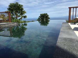 En vacker infinitypool med utsikt över havet och bergen.