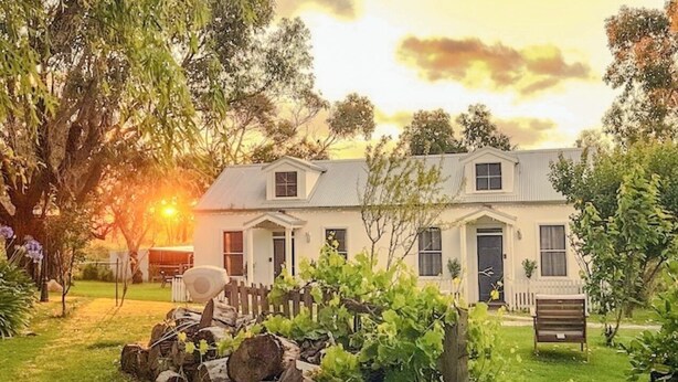 A two-story house with a front porch, a small garden, and a wooden fence. - Clonmara Country House & Cottages (Port Fairy)