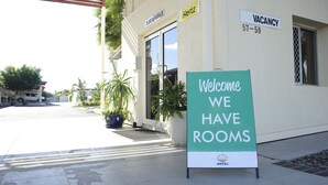 Ein Hotel Eingang mit Schild, das freie Zimmer anzeigt, und einem freundlichen Willkommensschild.