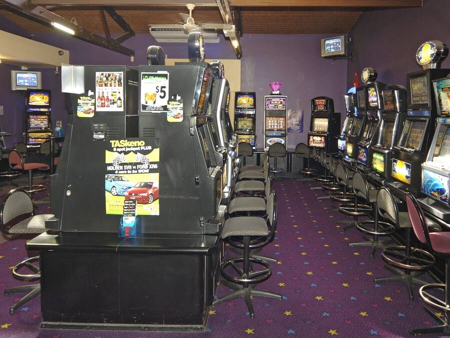 A row of slot machines in a casino with purple walls and a star-patterned carpet.