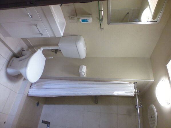 Un baño con inodoro, bidé y cortina de ducha.