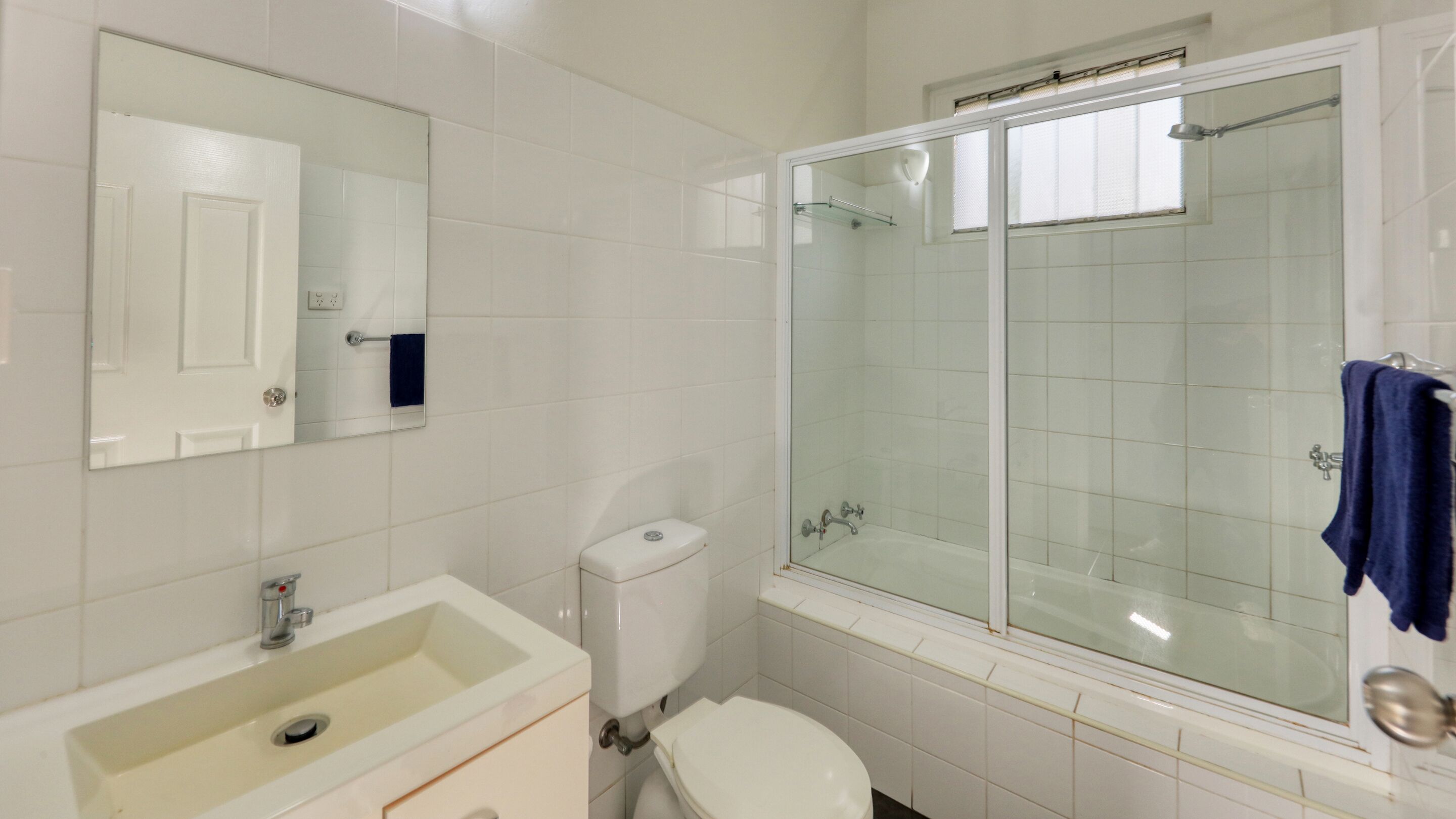 A bathroom with a sink, toilet, and glass-enclosed shower.