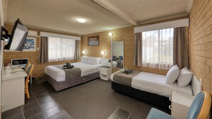 A hotel room with two beds, a desk with a computer, a microwave, and a dining area with chairs.