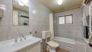 A bathroom with a sink, toilet, and bathtub.