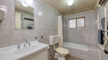 Un baño con lavamanos, inodoro y bañera.
