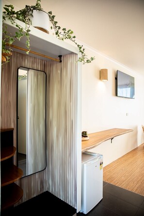 A modern kitchen with a wooden countertop, a white refrigerator, and a mirror. - HaKu (Brunswick Heads)