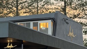 Un bâtiment moderne avec une enseigne portant le nom « Shaku » et un panneau lumineux au néon.
