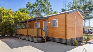 A small wooden cabin with a porch, a covered entryway, and a single window. - Charters Towers Tourist Park (Mosman Park)
