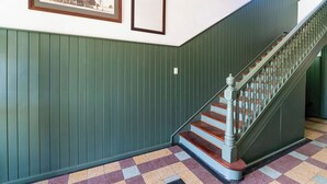 A staircase with a wooden handrail and a checkered floor pattern.
