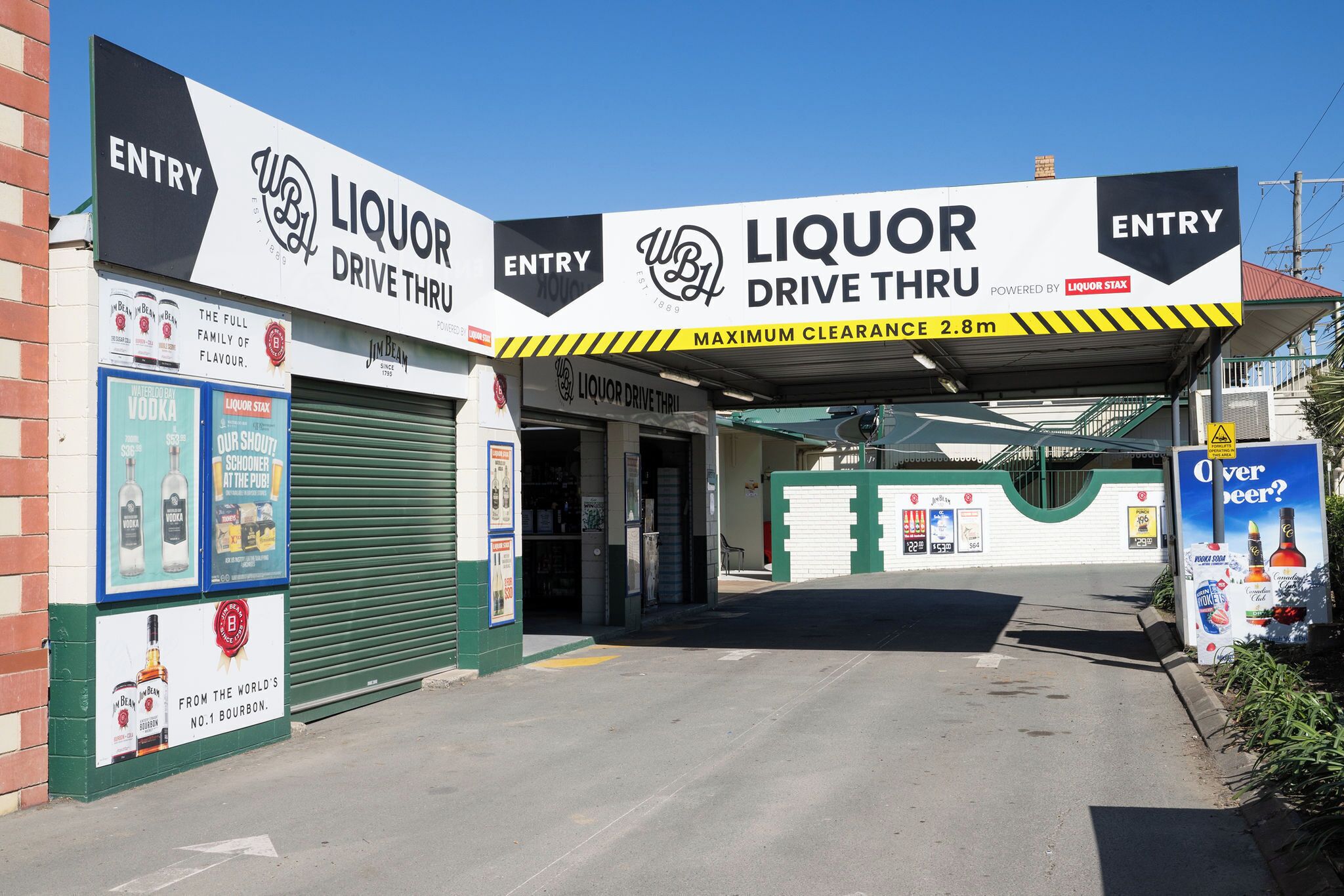 A Liquor Drive Thru with a maximum clearance of 2.8m, entry signs, and advertisements for Jim Beam and other brands.