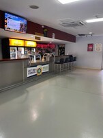 A bar area with a counter, seating, and a television screen.